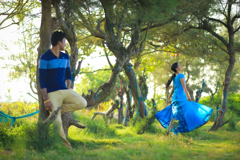 a man standing next to a woman in a blue dress, by Max Dauthendey, unsplash, sitting under a tree, bollywood, avatar image