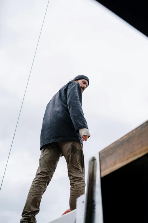 a man riding a skateboard down the side of a ramp, a picture, unsplash, happening, wearing farm clothes, standing on ship deck, wearing hunter coat, looking upwards