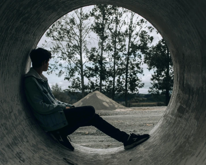 a man sitting in a pipe on a skateboard, pexels contest winner, visual art, looking out, teenager hangout spot, nature outside, human staring blankly ahead