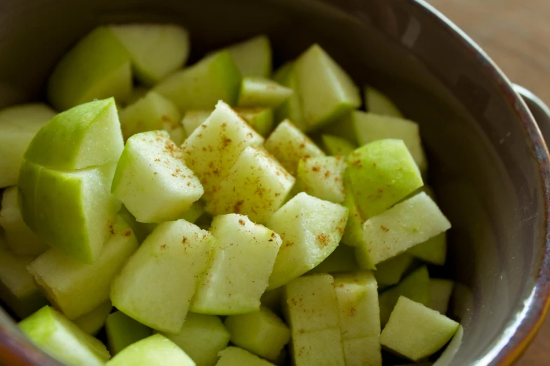 a close up of a bowl of sliced apples, cucumber, cinnamon, square, abcdefghijklmnopqrstuvwxyz