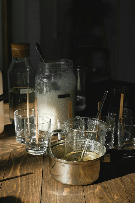 a wooden table topped with glasses and a pitcher, unsplash, process art, low-light, meth lab, seasonal, light water