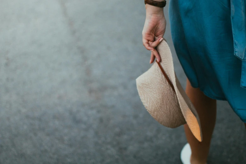 a woman in a blue dress holding a hat, pexels contest winner, casual summer clothes, simple muted colors, 1 2 9 7, perspective shot