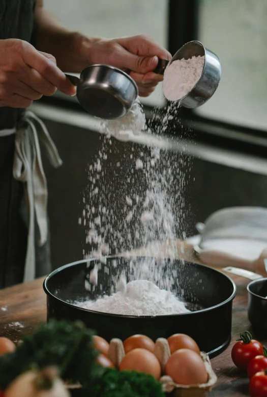 a person pouring flour into a pan on a table, inspired by Nishida Shun'ei, trending on unsplash, covered in salt, piping, ( ultra realistic, upclose