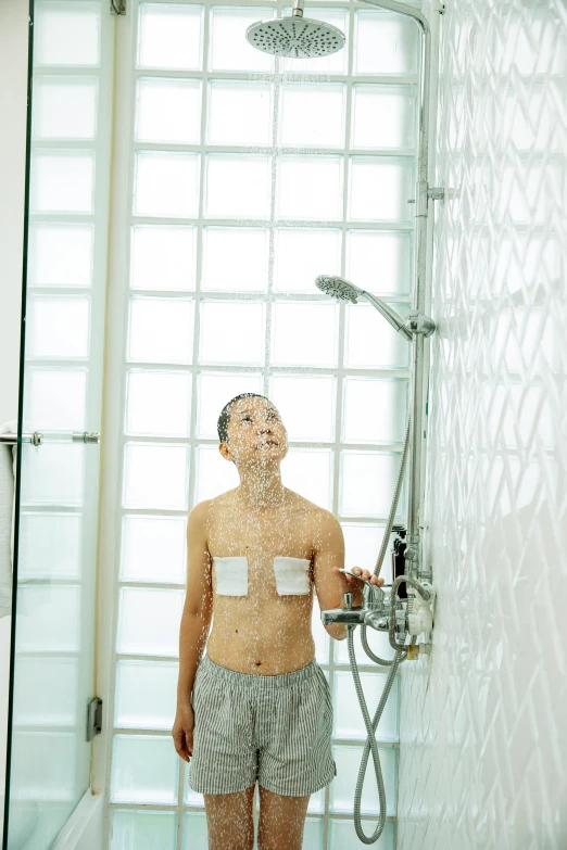 a man standing in a bathroom next to a shower, a digital rendering, by Nicolette Macnamara, unsplash, renaissance, an asian woman, rain sensor, transparent, square