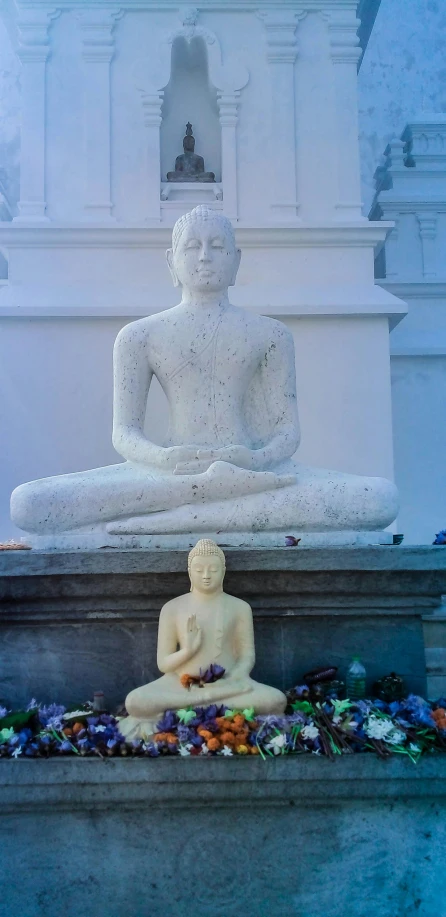 a statue of a person sitting in front of a building, padmasana, two still figures facing camera, sri lanka, pristine and clean