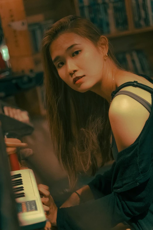 a woman sitting in front of a piano, inspired by Song Xu, unsplash, photorealism, resembling a mix of grimes, joy ang, intense expression, cai xukun