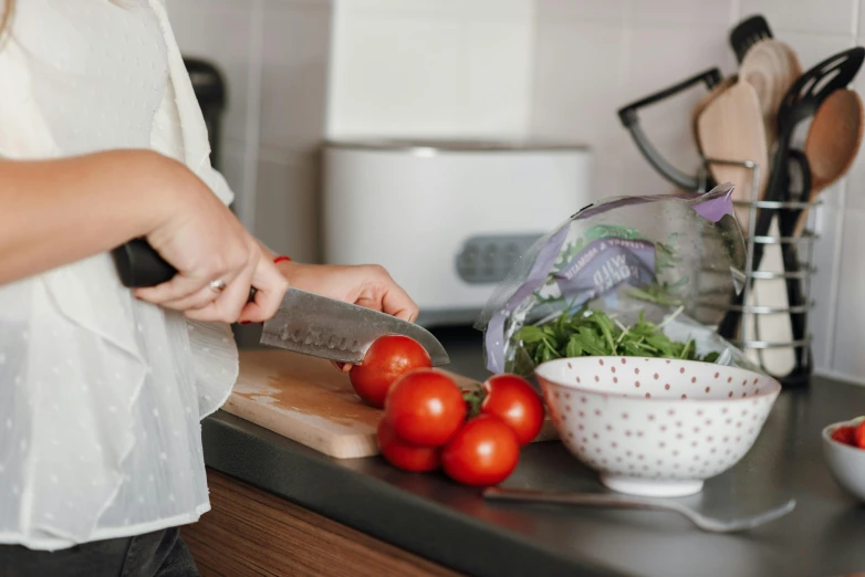 a woman is cutting tomatoes on a cutting board, by Julia Pishtar, pexels contest winner, 🦩🪐🐞👩🏻🦳, avatar image, plastic wrap, getting groceries