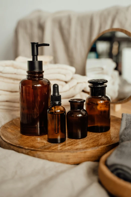 a bunch of bottles sitting on top of a wooden tray, a still life, unsplash, skin care, brown, amber, bedhead