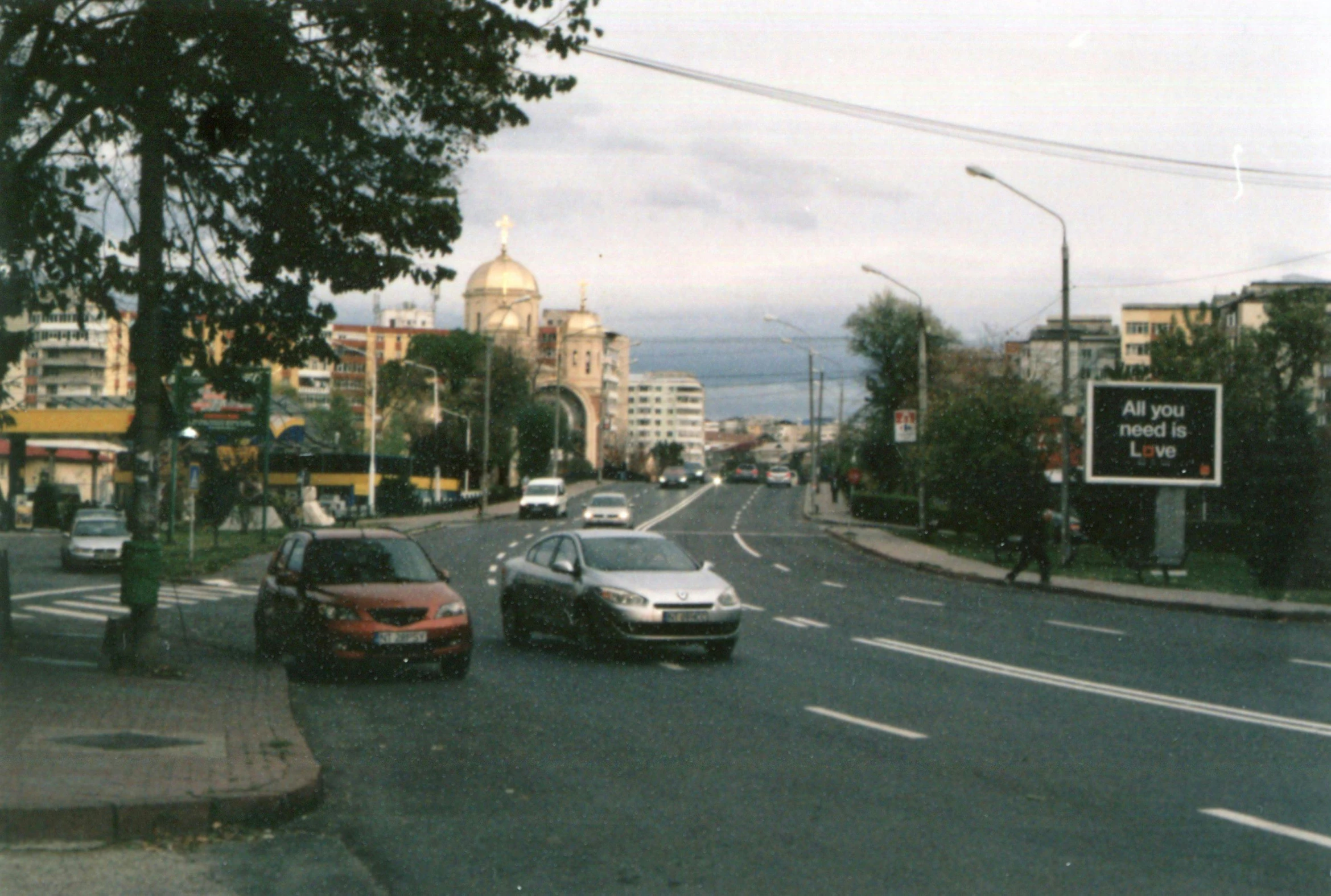 a street filled with lots of traffic next to tall buildings, an album cover, 000 — википедия, city of armenia quindio, 2 0 0 0's photo, view from side