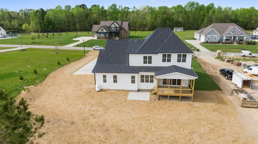 a large white house sitting on top of a lush green field, cg society contest winner, white plank siding, photo from above, profile image, 3 / 4 view from back