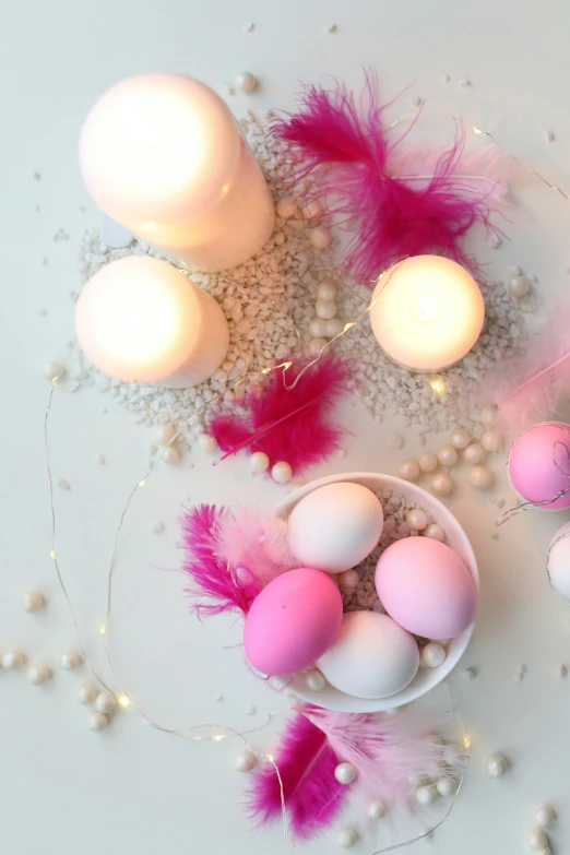 a white table topped with pink and white eggs, candle lights, vibrant lights, brightly lit, flatlay