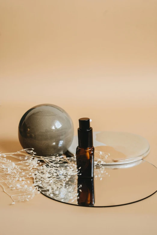 a bottle of perfume sitting on top of a glass table, a still life, by Winona Nelson, unsplash, glossy sphere, place setting, brown resin, full body image