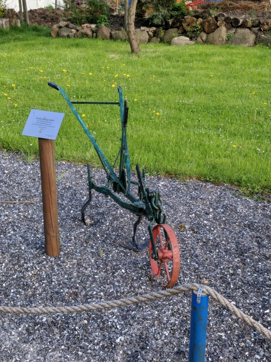 a green bike sitting on top of a gravel field, inspired by Christian Krohg, dribble, new sculpture, mine cart, holding a scythe, at the park, shepherd's crook