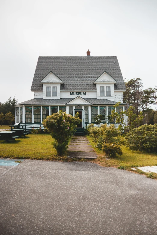 a white house sitting on the side of a road, vintage muted colors, at the museum, coastal, cottagecore