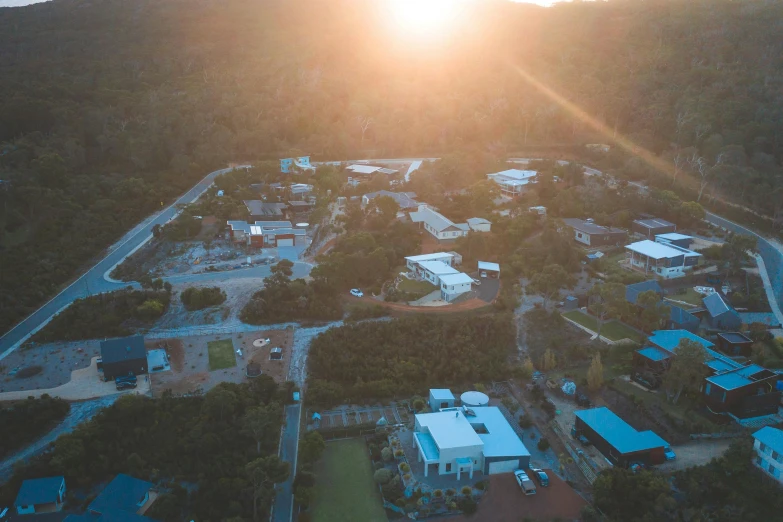 an aerial view of a city at sunset, by Lee Loughridge, happening, resort, school, sun flare, whealan