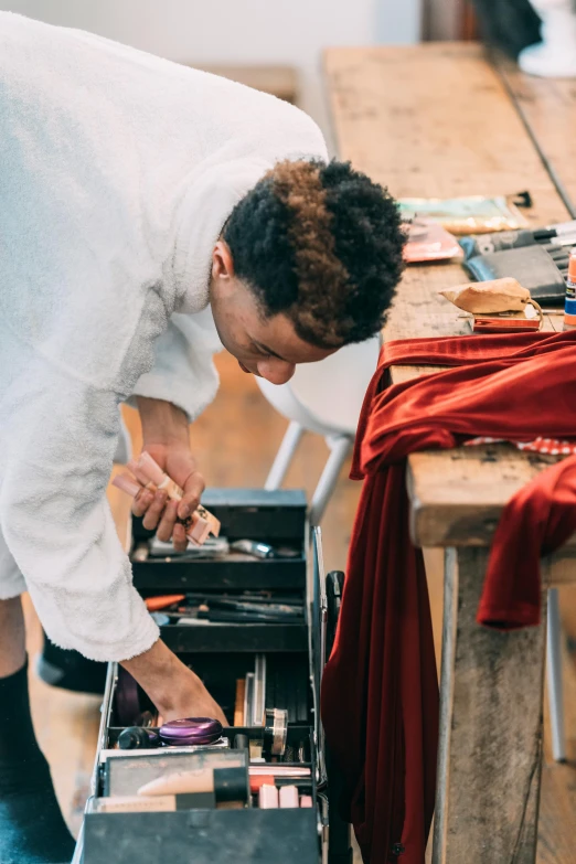 a man that is standing in front of a table, a silk screen, pexels contest winner, red hot soldering iron, white apron, thumbnail, streetwear