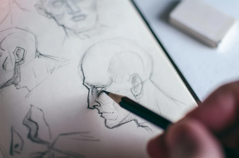 a person drawing on a piece of paper with a pencil, a drawing, inspired by Andrew Loomis, trending on pexels, face anatomy, marvel comic book drawing, sketchbook, smooth drawing