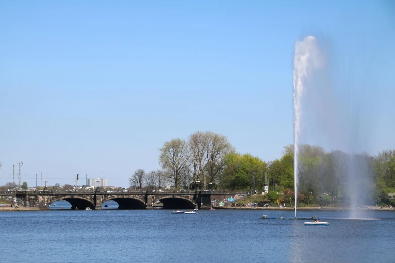 a large body of water with a bridge in the background, a statue, by Washington Allston, pexels contest winner, hurufiyya, norrlandsskog, perfect spring day with, spire, water powers water swirling