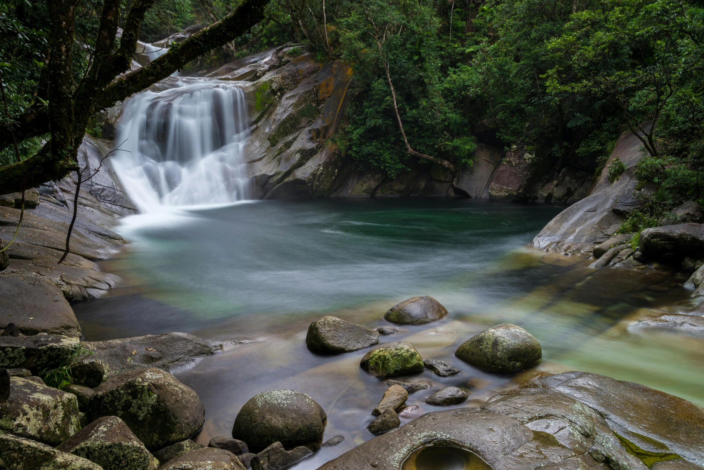 a waterfall flowing through a lush green forest, by Peter Churcher, unsplash contest winner, hurufiyya, tamborine, deep clear pools of water, thumbnail, rock pools