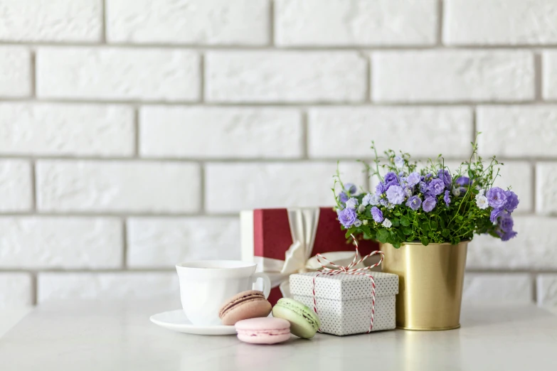 a white table topped with a vase filled with purple flowers, gifts, background image, macaron, thumbnail