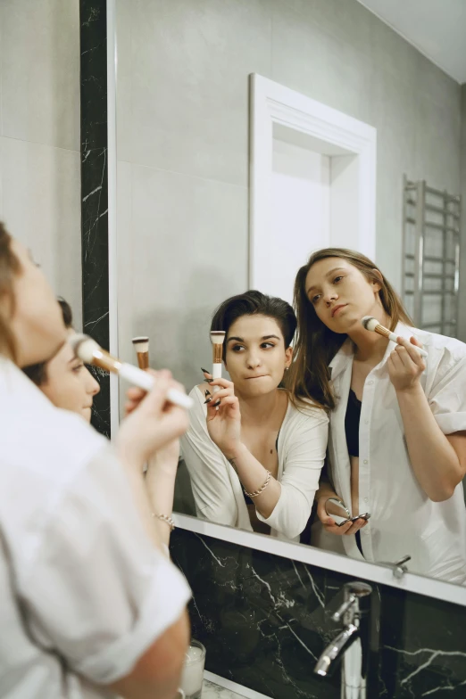 three women brushing their teeth in front of a mirror, by Julia Pishtar, pexels contest winner, brown hair in two buns, teenage, wearing white robe, lots of makeup