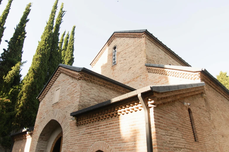 a red fire hydrant sitting in front of a brick building, an album cover, by Arthur Sarkissian, romanesque, roof with vegetation, the narthex, фото девушка курит, located in hajibektash complex