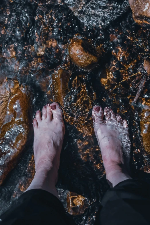 the feet of a person standing in a stream of water, pexels contest winner, burnt forest, ✨🕌🌙, gooey skin, sydney hanson