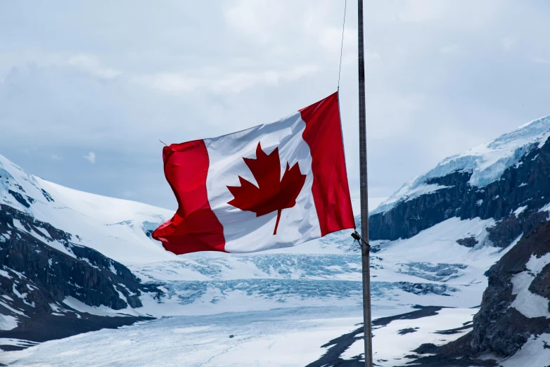 a canadian flag blowing in the wind on top of a mountain, by Julia Pishtar, pexels contest winner, symbolism, icy glaciers, avatar image, 🚿🗝📝