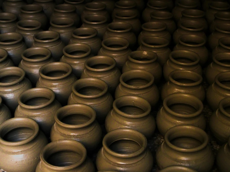 a group of clay pots sitting next to each other, inspired by Nam Gye-u, unsplash, mingei, in a massive cavernous iron city, pyongyang, cellar, photograph credit: ap