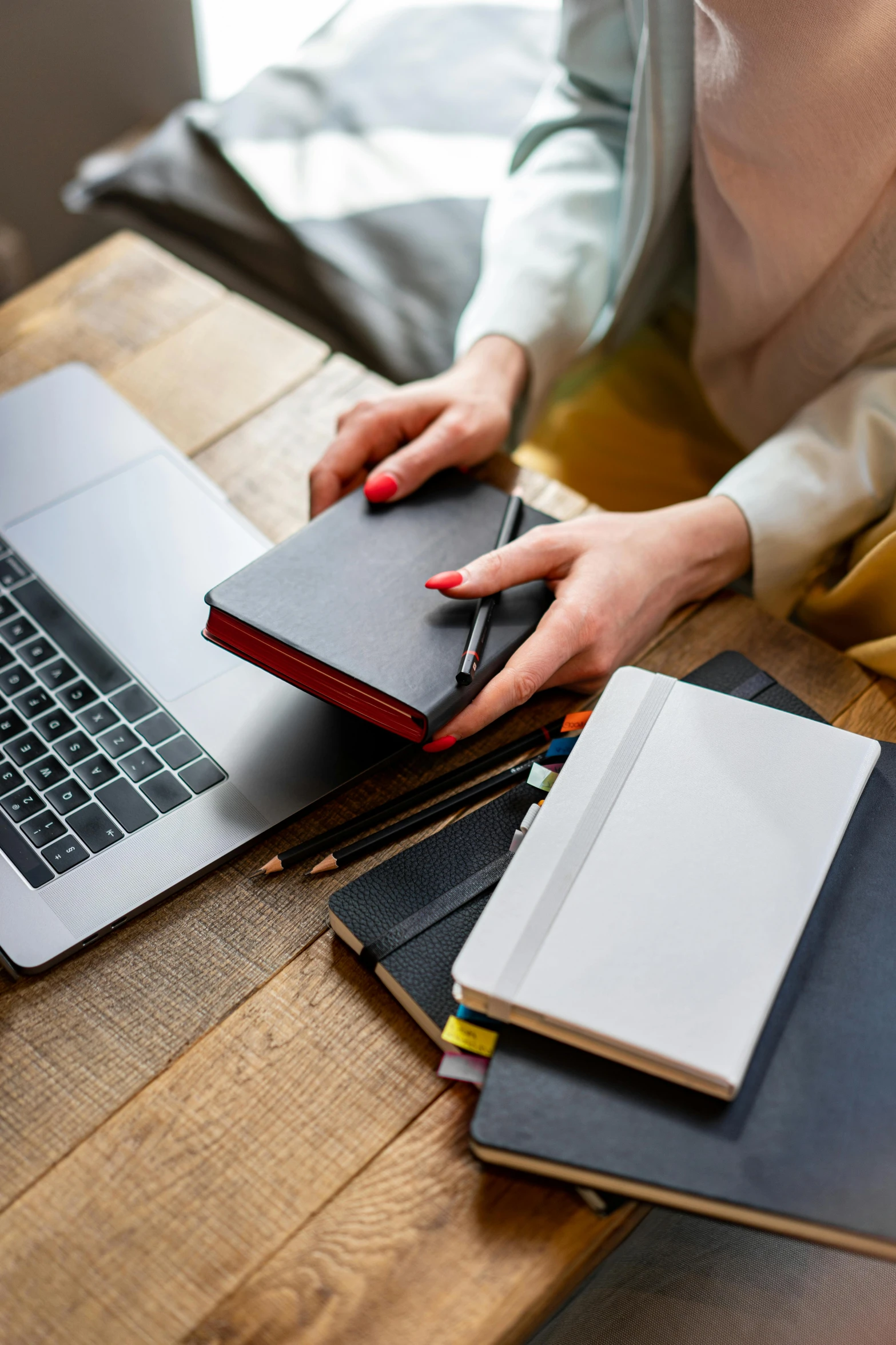 a woman sitting at a table with a laptop and notebook, sleek spines, thumbnail, small, unbeatable quality