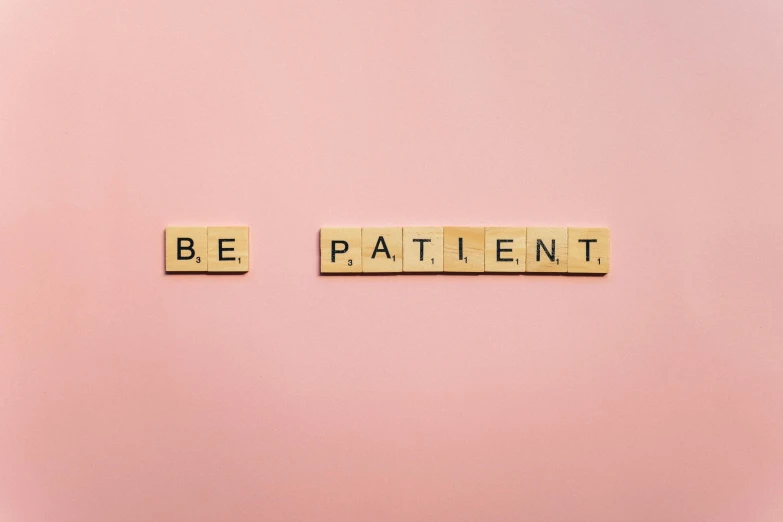 the word be patient spelled with scrabbles on a pink background, by Emma Andijewska, pexels, aestheticism, medical photography, repeating patterns, wall art, on a pale background