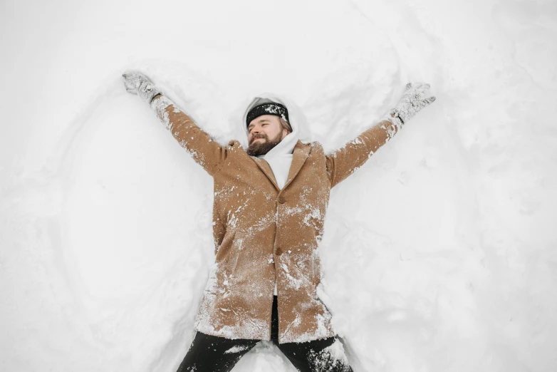 a man laying in the snow making a snow angel, pexels contest winner, bearded, brown, avatar image, triumphant pose