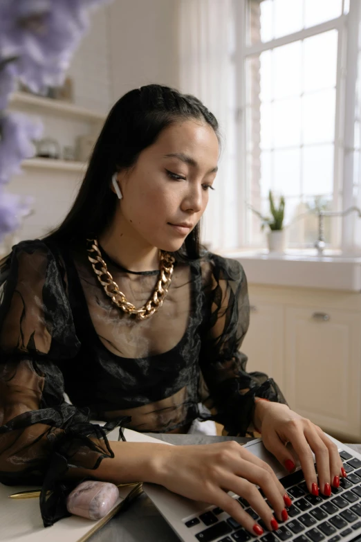 a woman sitting in front of a laptop computer, wearing gold detailed choker, reading, gemma chen, wearing a designer top