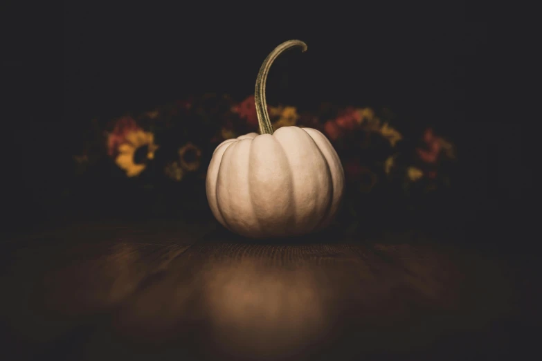 a white pumpkin sitting on top of a wooden table, by Alison Geissler, unsplash, ☁🌪🌙👩🏾, halloween theme, background image, instagram picture