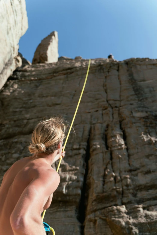 a man on a rock climbing up the side of a cliff, by Peter Churcher, long shot from the back, sunbathed skin, single line, charts