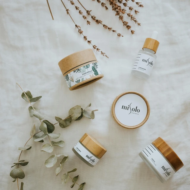 a variety of skin care products laid out on a bed, a picture, by Micha Klein, pexels contest winner, dau-al-set, made of bamboo, packaging design, mulato, decoration