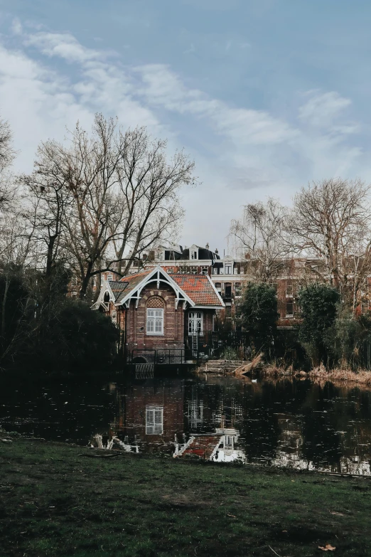 a house sitting on top of a lush green field, a picture, by Jan Tengnagel, pexels contest winner, art nouveau, in a park and next to a lake, utrecht, winter, tiny house