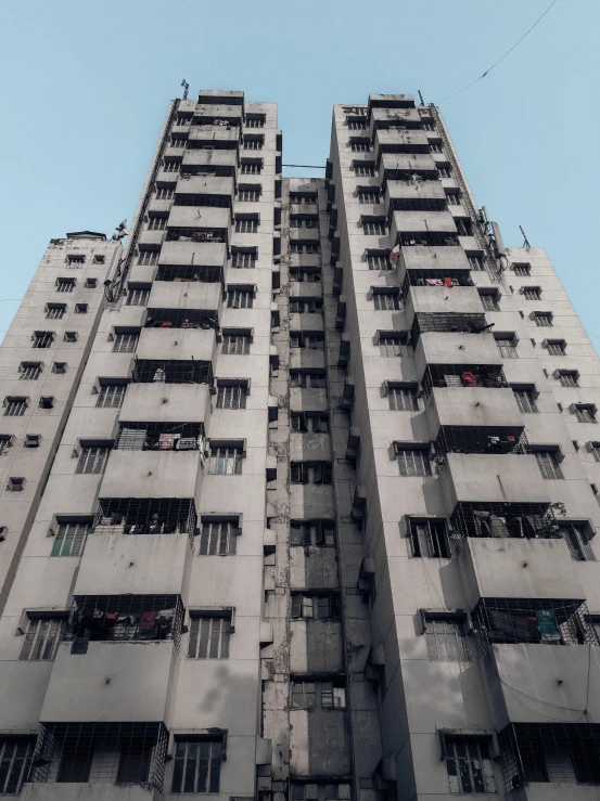 a tall building with lots of windows and balconies, an album cover, pexels contest winner, brutalism, kowloon walled city style, simple brutalist architecture, poor quality, taken on go pro hero8