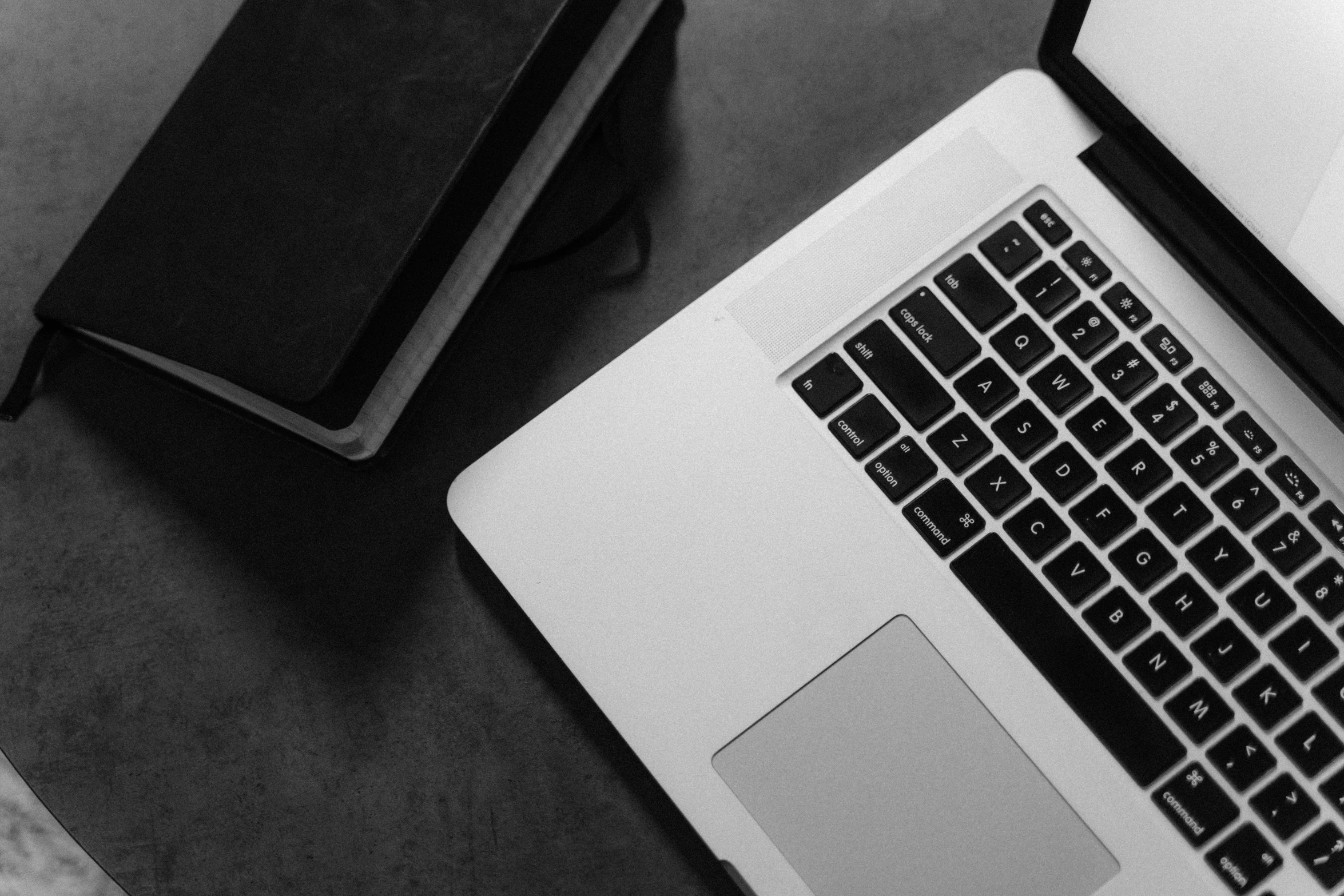 a laptop computer sitting on top of a table next to a book, a black and white photo, pexels, black an white, resources background, background image, greg rutkowski ”