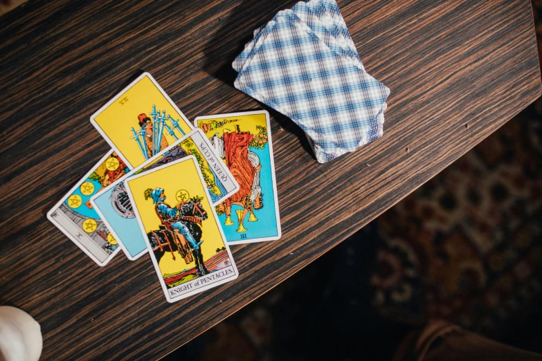 a tarot deck sitting on top of a wooden table, by Julia Pishtar, unsplash, playing poker in a saloon, multicoloured, graphic print, cowboy shot