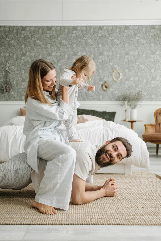 a man and woman laying on a bed with a little girl, pexels contest winner, renaissance, wearing a white button up shirt, playing, rugs, thumbnail