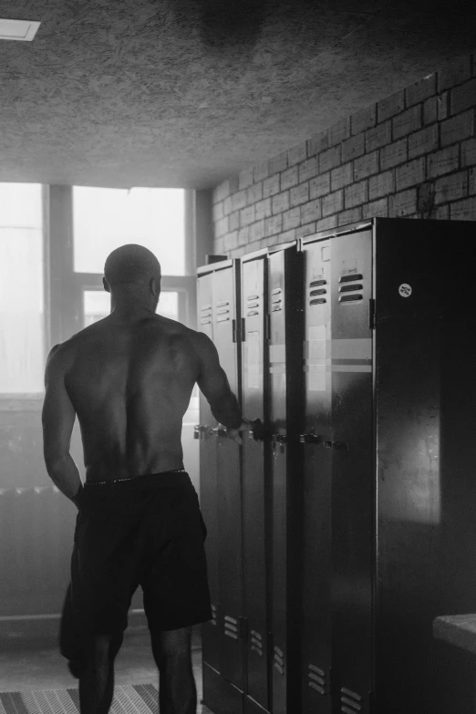 a black and white photo of a man in a locker, by Adam Marczyński, rear side portrait of a muscular, 15081959 21121991 01012000 4k, summer morning, sergey krasovskiy