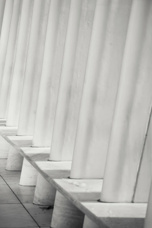 a black and white photo of a row of benches, unsplash, neoclassicism, pillars of ice background, square lines, greek white marble, sittin