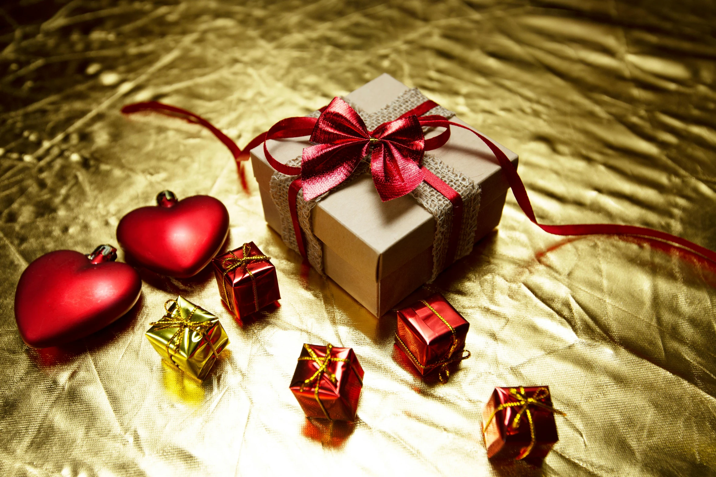 a gift box sitting on top of a table next to christmas ornaments, by Julia Pishtar, pexels, romanticism, gold and red metal, square, hearts, brown