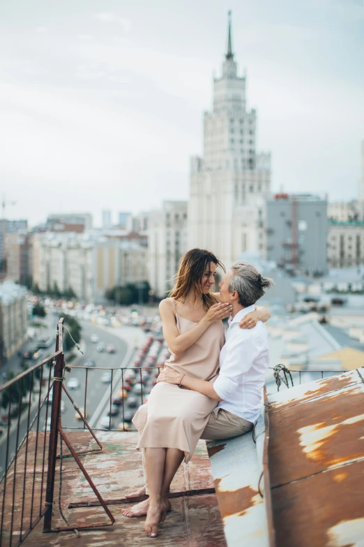 a man and a woman sitting on top of a building, pexels contest winner, romanticism, russian city, rooftop romantic, square, with stalinist style highrise