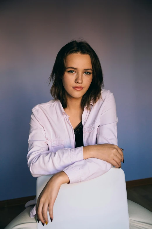 a woman sitting on top of a white chair, a colorized photo, trending on unsplash, photorealism, frank dillane, confident smirk, 1 6 years old, casual pose