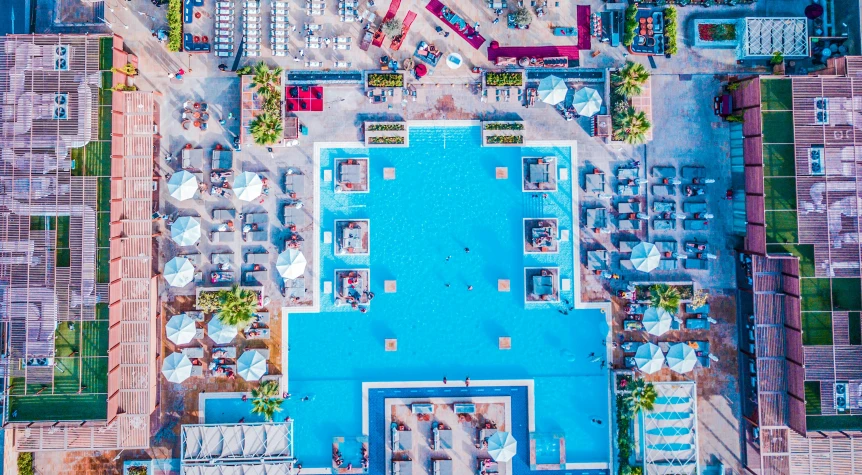 an aerial view of a swimming pool surrounded by buildings, pexels contest winner, azure and red tones, square, pool party, cyprus