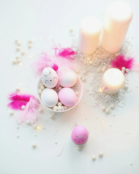 a white bowl filled with pink and white eggs, a picture, by Alice Mason, pexels contest winner, candles, white neon details, feathers, soft colours scheme