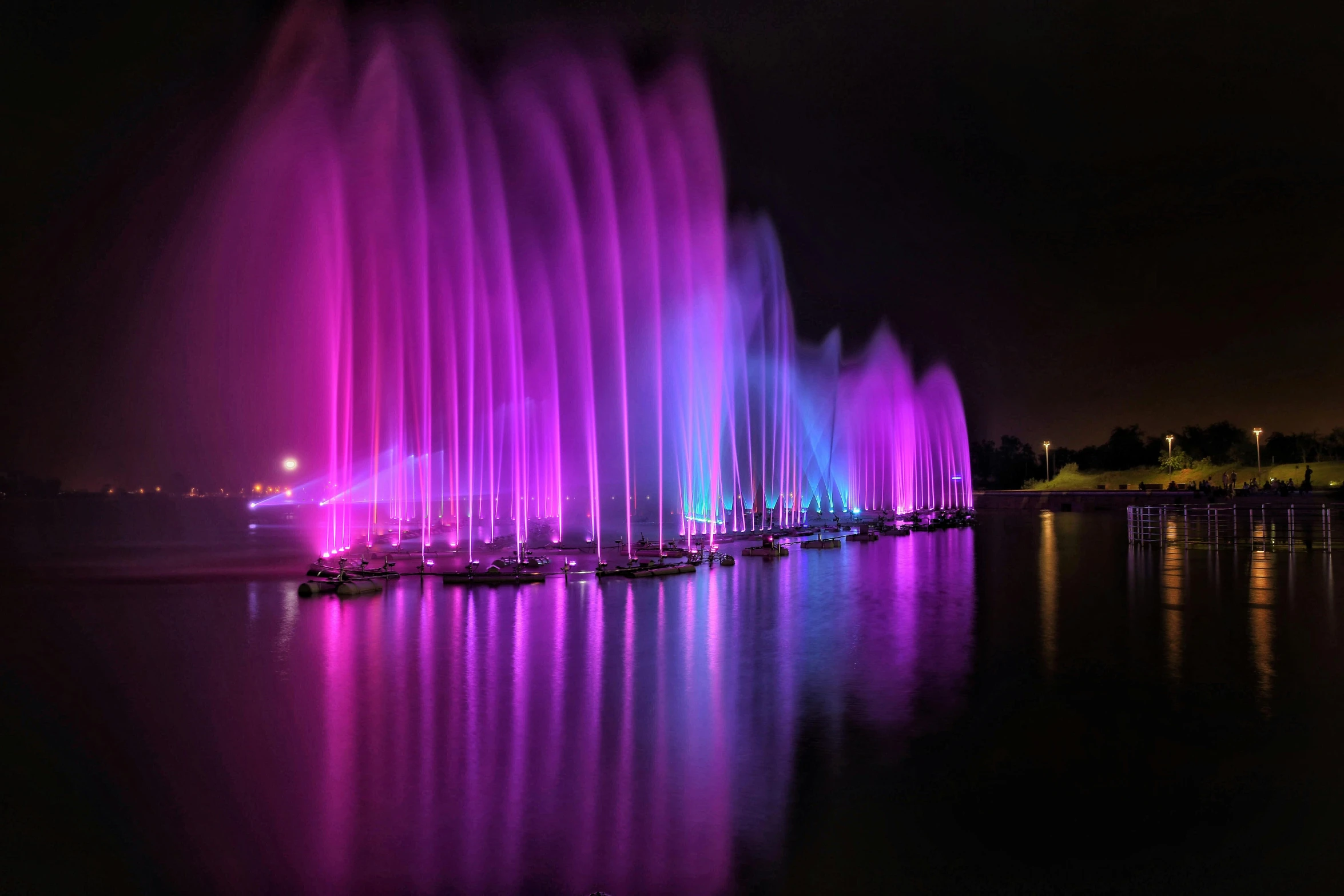 a colorful water fountain is lit up at night, pexels contest winner, pink and purple, waterfals, various colors, waterscape