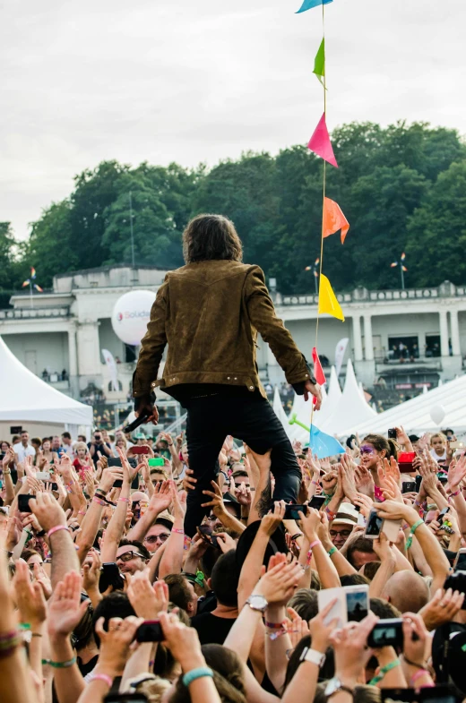 a man standing on top of a crowd of people, an album cover, pexels contest winner, happening, jonny greenwood, 🚿🗝📝, cheering crowd, joe keery